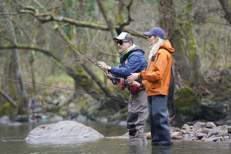 young woman learning to fly fishing with a guide